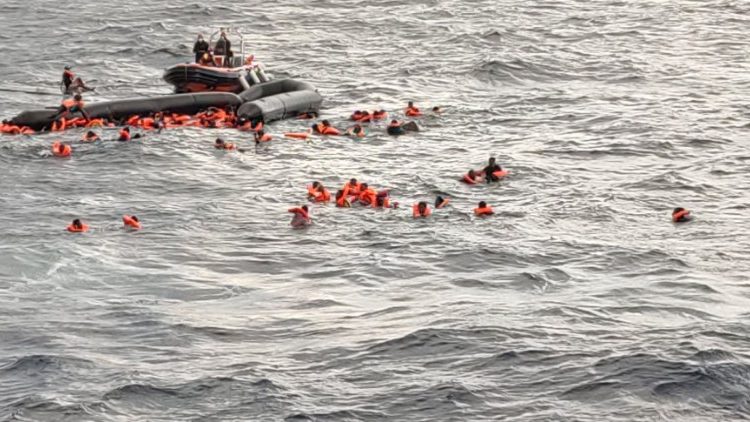 Uchodźcy w wodzie czekający na ratunek.