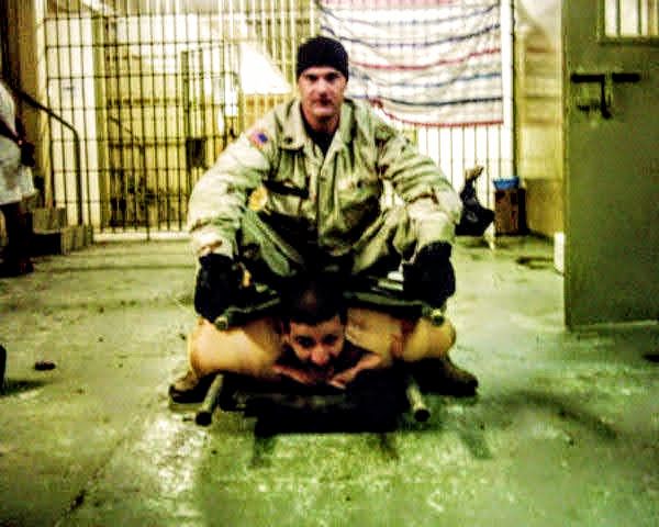 Sierżant armii amerykańskiej znęca się nad Irakijczykiem w więzieniu tortur Abu Ghraib.